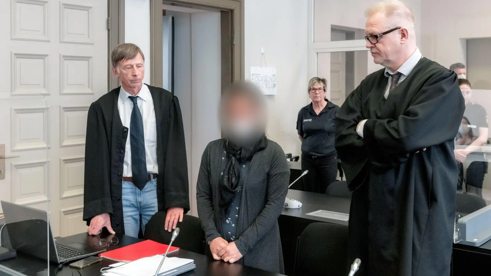 Die Angeklagte IS-Rückkehrerin aus Bremen steht zwischen ihren Verteidigern Jacob Hösl (r) und Johannes Pausch in einem Saal des Oberlandesgericht. (Foto: Markus Scholz/dpa-Pool/dpa)