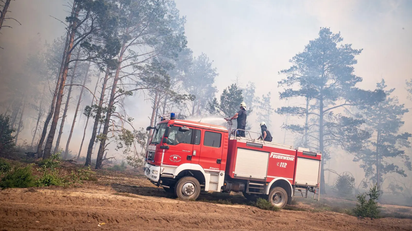 Einsatzkräfte der Feuerwehr bekämpfen in einem Waldstück nahe Jüterbog das Feuer. (Foto: Fabian Sommer/dpa)