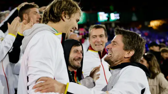 Alexander Zverev (l) und der deutsche Teamkapitän Michael Kohlmann jubeln über den Sieg gegen Belgien. (Foto: Frank Molter/dpa)
