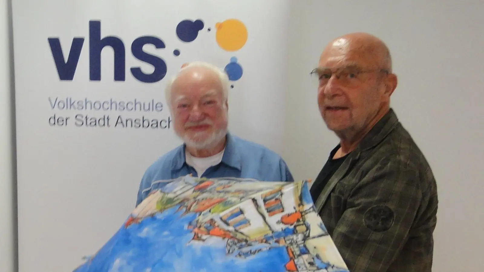 Klaus Miksch (links) und Bodo Drechsler wurden als langjährige VHS-Dozenten verabschiedet. Jeder von ihnen erhielt unter anderem einen farbenfrohen Ansbach-Schirm. (Foto: Winfried Vennemann)