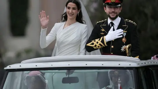 Das glückliche Brautpaar: Kronprinz Hussein bin Abdullah und Radschwa Al Saif fahren in einem offenen Wagen durch Amman. (Foto: Nasser Nasser/AP)