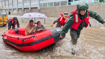 Retter helfen mit Schlauchbooten nach den starken Regenfällen in Qinzhou. (Foto: Ao Shuaichang/X/XinHua/dpa)