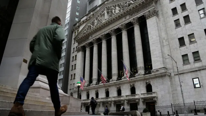 Menschen passieren die Fassade der New Yorker Börse. (Foto: Peter Morgan/AP/dpa)