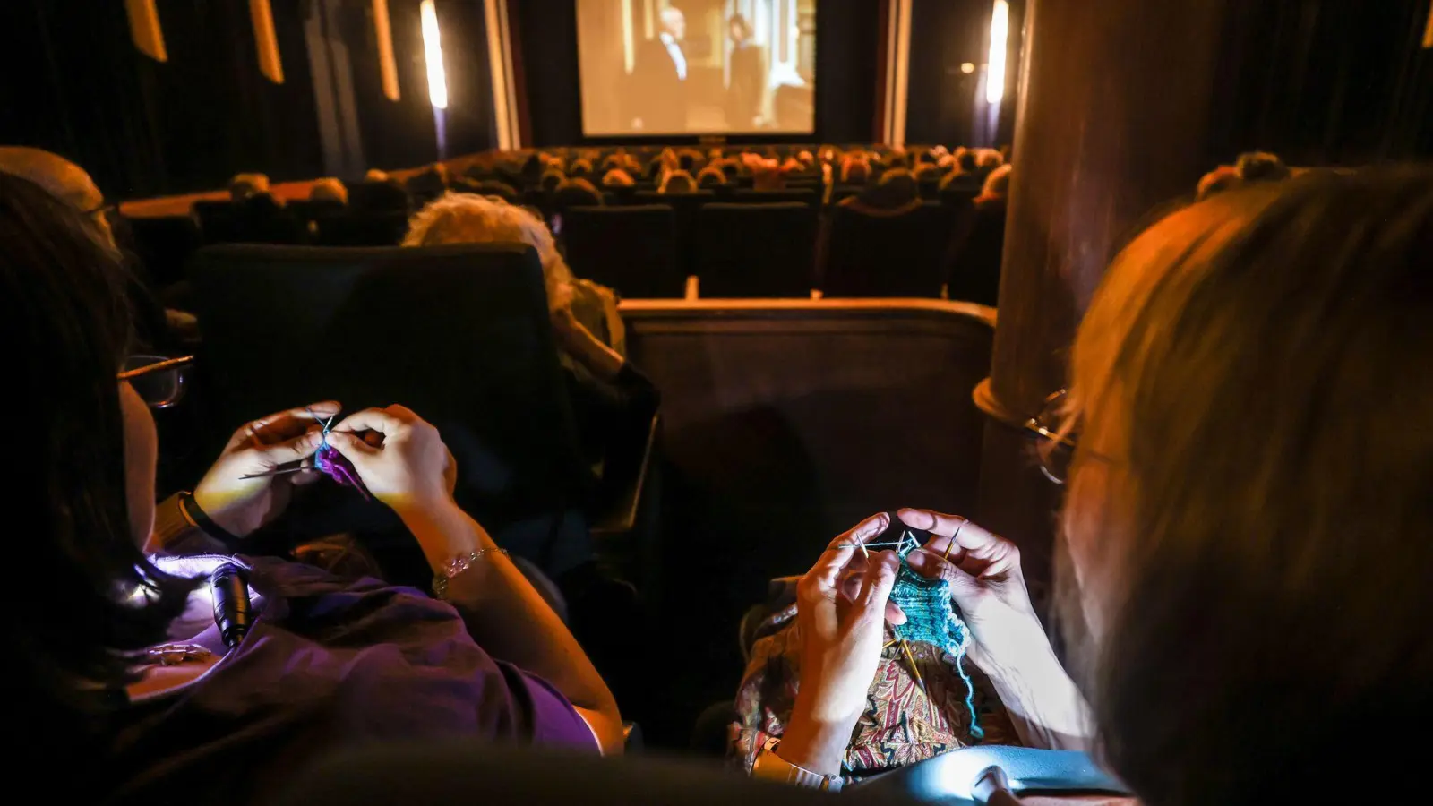 Beim „Strick-Kino“ wie hier in Mannheim stricken die Kinobesucher(innen) und genießen nebenher einen Film. (Foto: Christoph Schmidt/dpa)