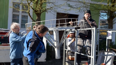 Mit vereinten Kräften wird das Metallgestell auf den Hubsteiger gehievt – auch Hausherr Frieder Müller-Maatsch (links) packt mit an. (Foto: Johannes Zimmermann)