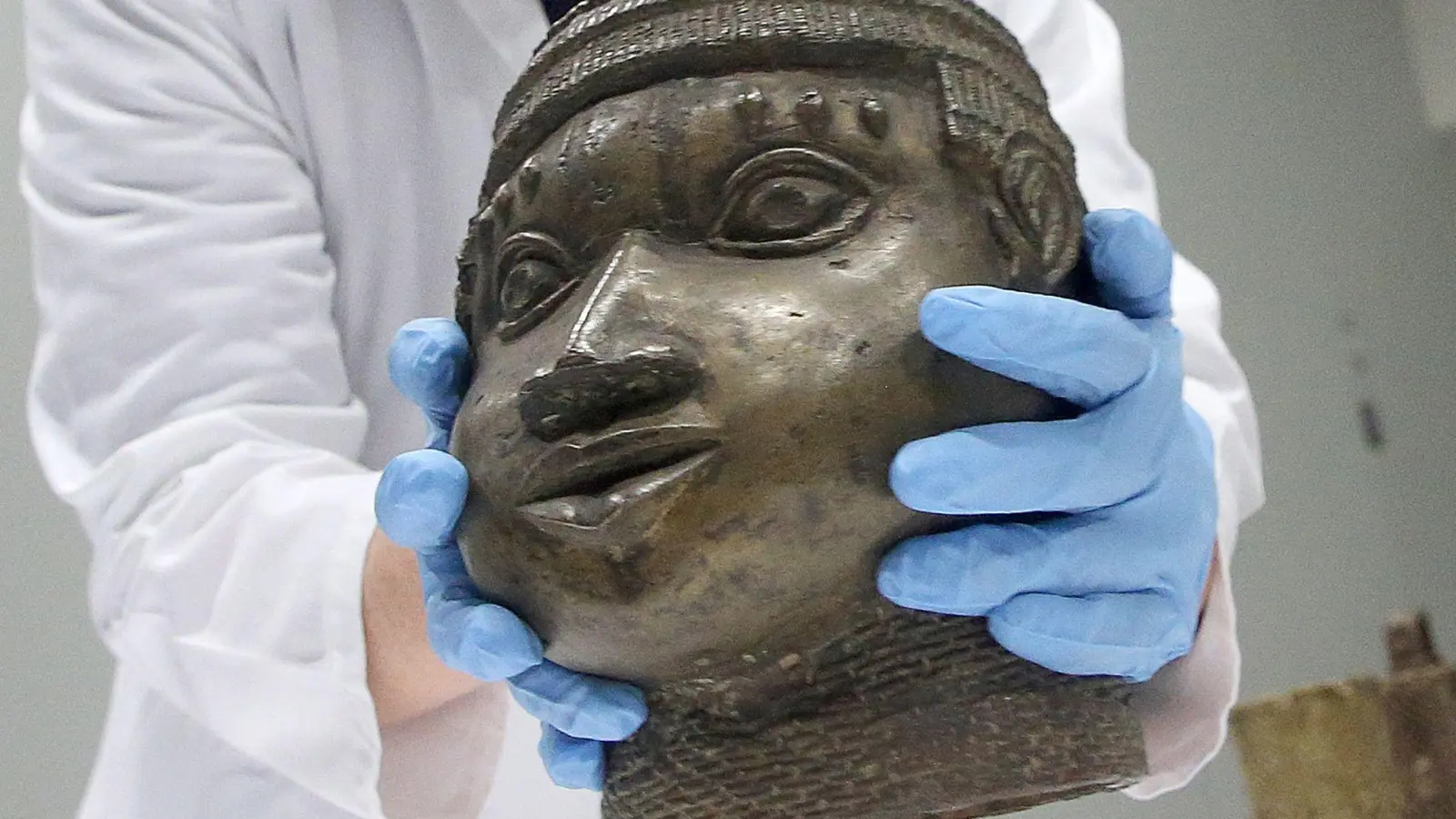 Eine Museumsmitarbeiterin verpackt eine der Benin-Bronzen, die für die Rückgabe nach Nigeria im Ethnologischen Museum Dahlem zusammen gestellt wurden. (Foto: Wolfgang Kumm/dpa)