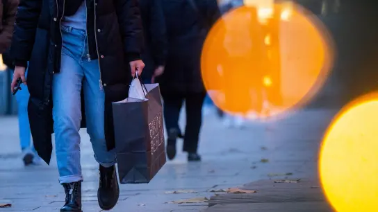 Eine Passantin geht mit einer Einkaufstasche durch die Innenstadt. (Foto: Monika Skolimowska/dpa-Zentralbild/dpa/Symbolbild)