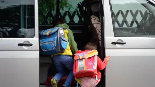 Schulkinder steigen in ein privates Fahrzeug. Elterntaxis verstopfen oft die Straßen vor den Schulen. (Foto: Ralf Hirschberger/ZB/dpa)