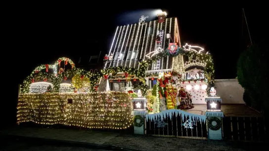 Zahlreiche Lichter erstrahlen am weihnachtlich geschmückten Haus der Familie Borchart. Vom 1. Advent bis zum Jahresende erstrahlt das Haus der Familie mit Weihnachtsdekoration und rund 60.000 Lichtern. (Foto: Hauke-Christian Dittrich/dpa)