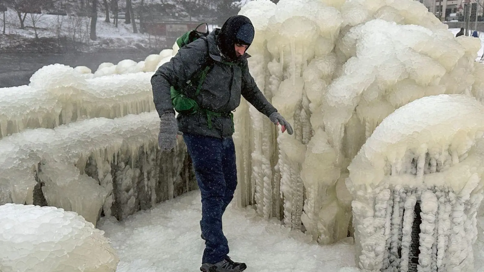 Unweit der Great-Falls-Wasserfälle von Paterson im US-Bundesstaat New Jersey geht ein Mann über eine dicke Eisschcht. (Foto: Ted Shaffrey/AP/dpa)