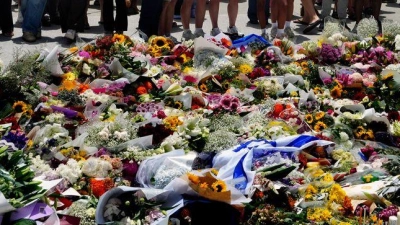 Menschen versammelt sich einen Tag nach einer Schießerei am Bondi Beach in Sydney um ein Blumendenkmal. (Foto: Mark Baker/AP/dpa)