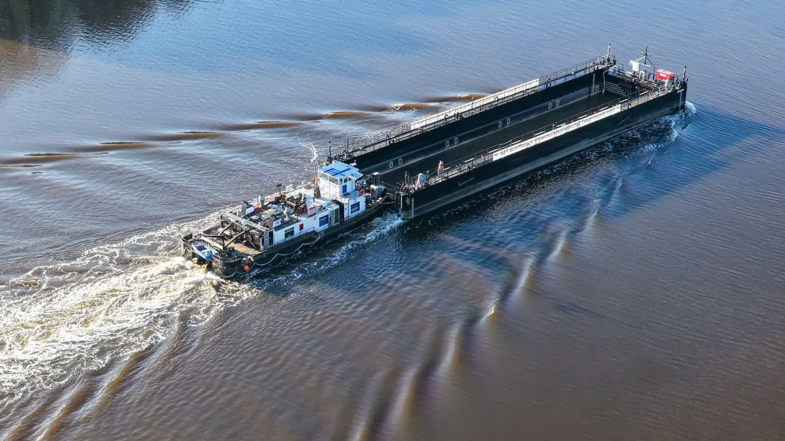 Ein Lastkahn, geschoben von dem Schubschiff „Hans“ fährt auf dem Nord-Ostsee-Kanal. (Foto: Bodo Marks/dpa)