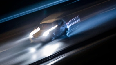 Ein Fahrzeug braust in der Dunkelheit über eine Autobahn. Wie schnell darf man eigentlich fahren? Diese Frage sorgt erneut für Diskussion. (Foto: picture alliance / Frank Rumpenhorst/dpa/Symbolbild)