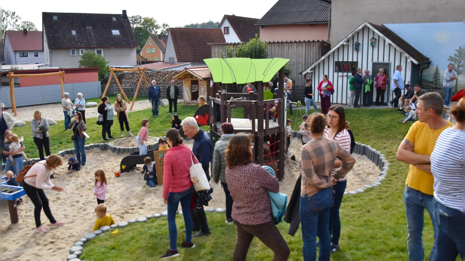 Die Gäste informierten sich bei einem Rundgang auch über die Außenanlagen, während die Kinder schon mal die Spielgeräte ausprobierten. (Foto: Werner Wenk)
