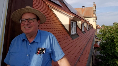 Jürgen Strauß vor dem rötlichen Brauhausdach mit PV-Anlagen. (Foto: Heinz Wraneschitz)