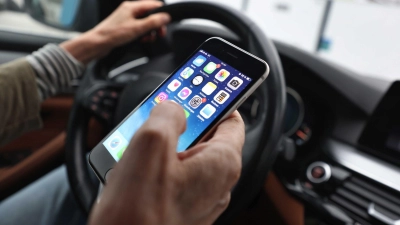 Ein „kurzer“ Blick auf das Handy ist bisher erlaubt - wenn man es nicht in die Hand nimmt. (Symbolbild) (Foto: Karl-Josef Hildenbrand/dpa)