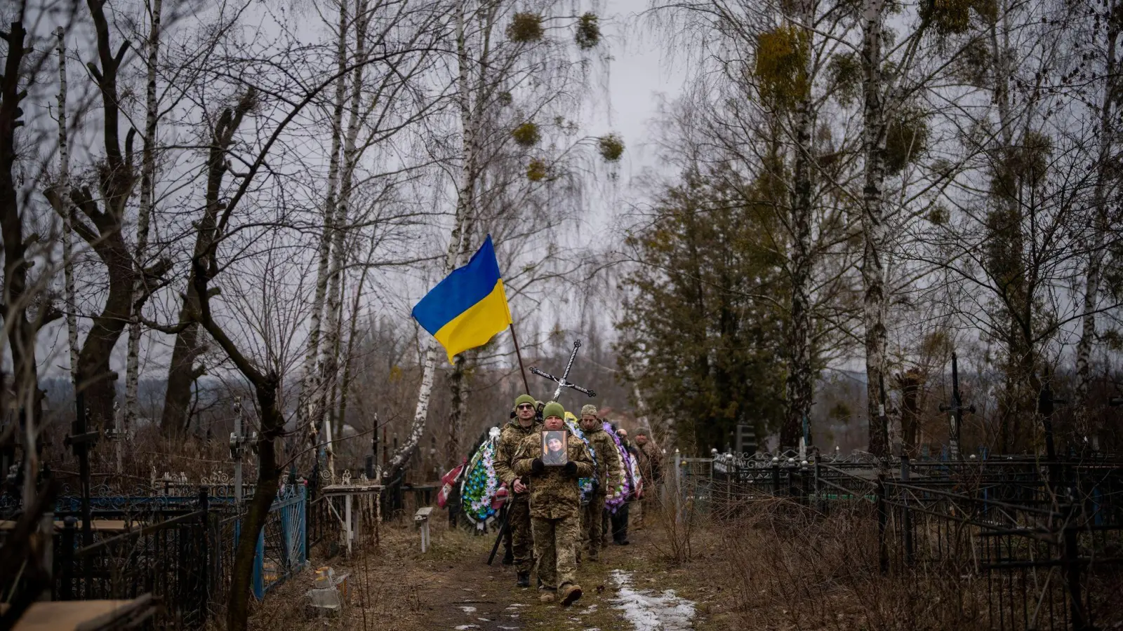 Ukrainische Soldaten tragen den Sarg eines Kameraden bei dessen Beerdigung in Butscha. ER wurde bei den Kämpfen um Bachmut getötet. (Foto: Emilio Morenatti/AP/dpa)