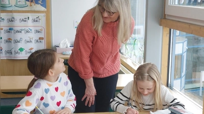Anna und Isabell schaffen die Hausaufgaben meist selbst. Für die Fragen der Grundschüler stehen die Betreuer wie hier Petra Müller parat. (Foto: Sandra Buchwald)