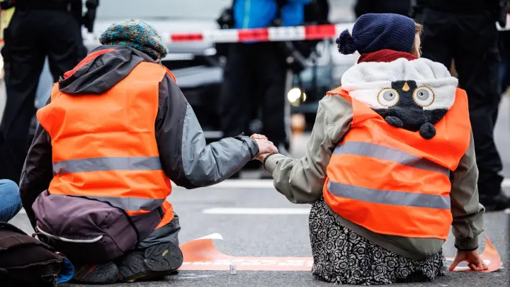 Aktivisten der „Letzten Generation“ haben sich am Stachus auf die Straße geklebt. (Foto: Matthias Balk/dpa)