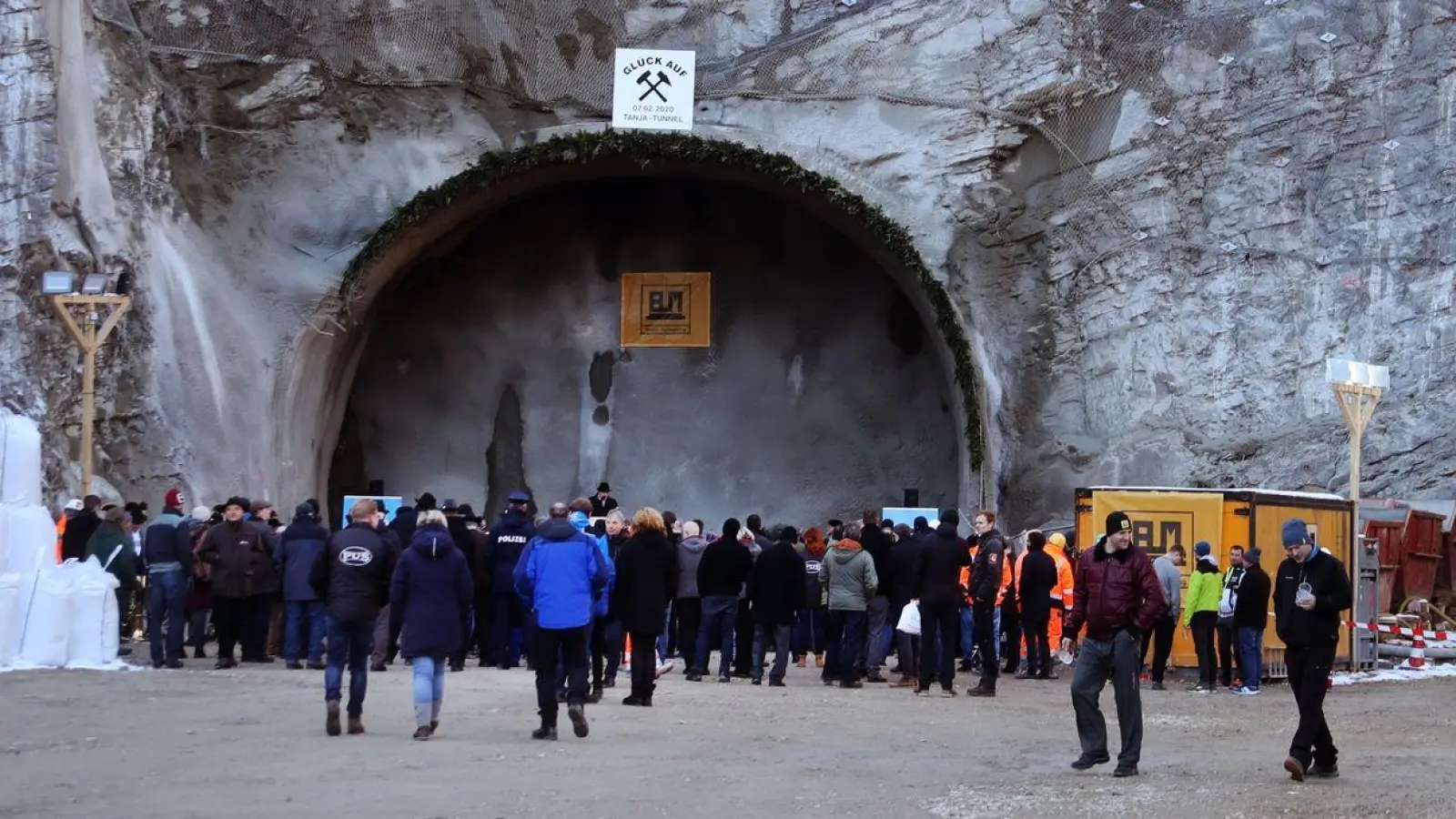 Arbeiter und Gäste stehen nach dem offiziellen Tunnelanschlag vor dem zukünftigen Nordportal des Kramertunnels. (Foto: Stephan Jansen/dpa)