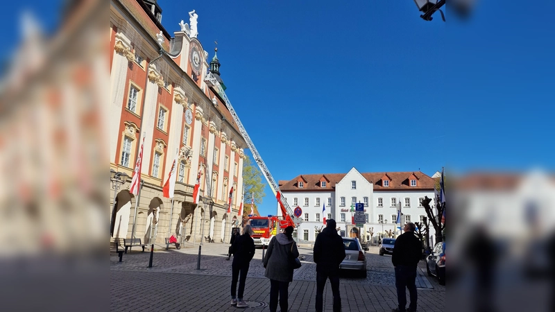 Der ungewöhnliche Einsatz der Feuerwehr an der Rathaus-Uhr in Bad Windsheim erregte bei den vorbeigehenden Menschen große Aufmerksamkeit. (Foto: Josh Reuter)