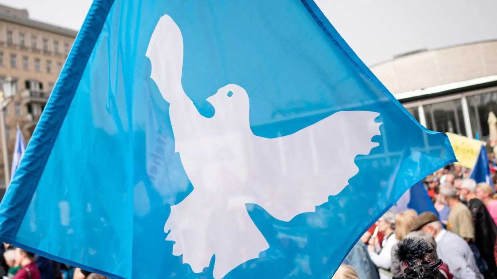 Eine Flagge mit der Friedenstaube ist auf dem traditionellen Ostermarsch in Berlin zu sehen. (Foto: Fabian Sommer/dpa)