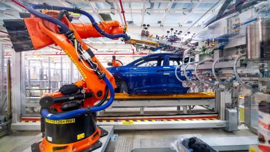 Roboter montieren Bauteile eines E-Autos. Der Halbleitermangel dürfte die Autoindustrie einer Studie zufolge bis mindestens 2024 bremsen. (Foto: Sina Schuldt/dpa)