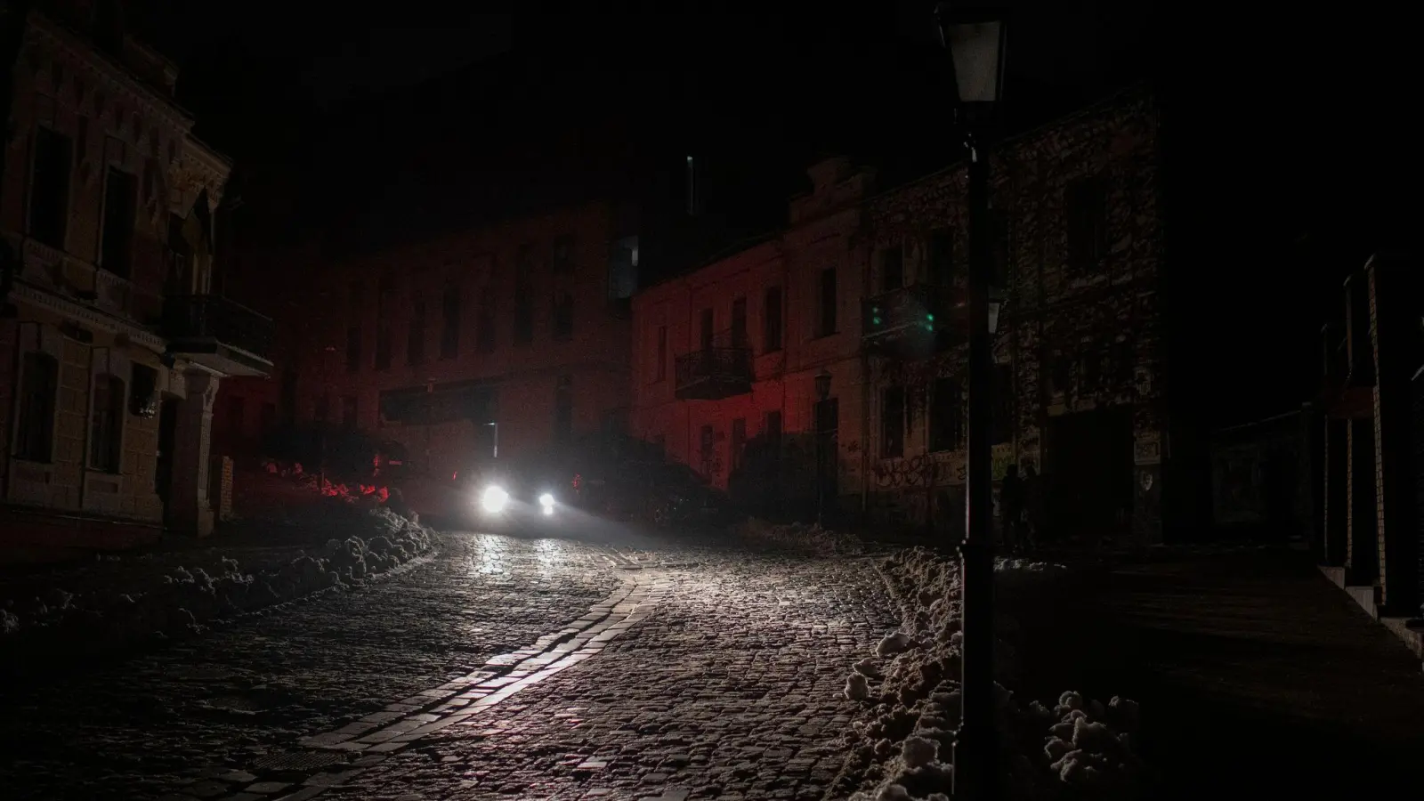 Ein Fahrzeug fährt während eines Stromausfalls nach einem russischen Raketenangriff. (Foto: Andrew Kravchenko/AP/dpa)