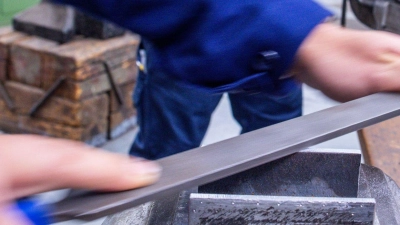 Lehrlinge arbeiten mit der Metallfeile an Schraubstöcken in einer Lehrwerkstatt. (Foto: Jens Büttner/dpa)