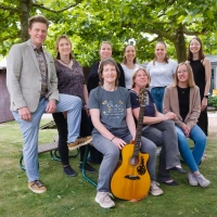 Freuen sich auf ein Open-Air-Konzert im Pfarrgarten: Chorleiterin Karin Dietlein (mit Gitarre), Pfarrerin Simone Sippel (rechts neben ihr), Sänger David Lugert und der „Chor ohne Namen”.  (Foto: Martin Stumpf)