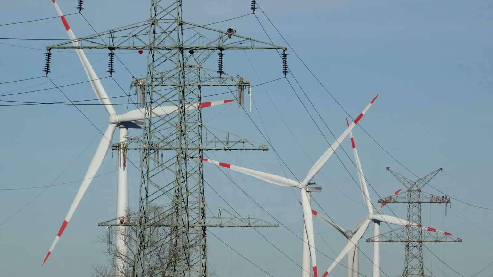 Windkraftanlagen und Strommasten - beides steht für den Ausbau erneuerbare Energie. (Symbolbild) (Foto: Carsten Rehder/dpa)