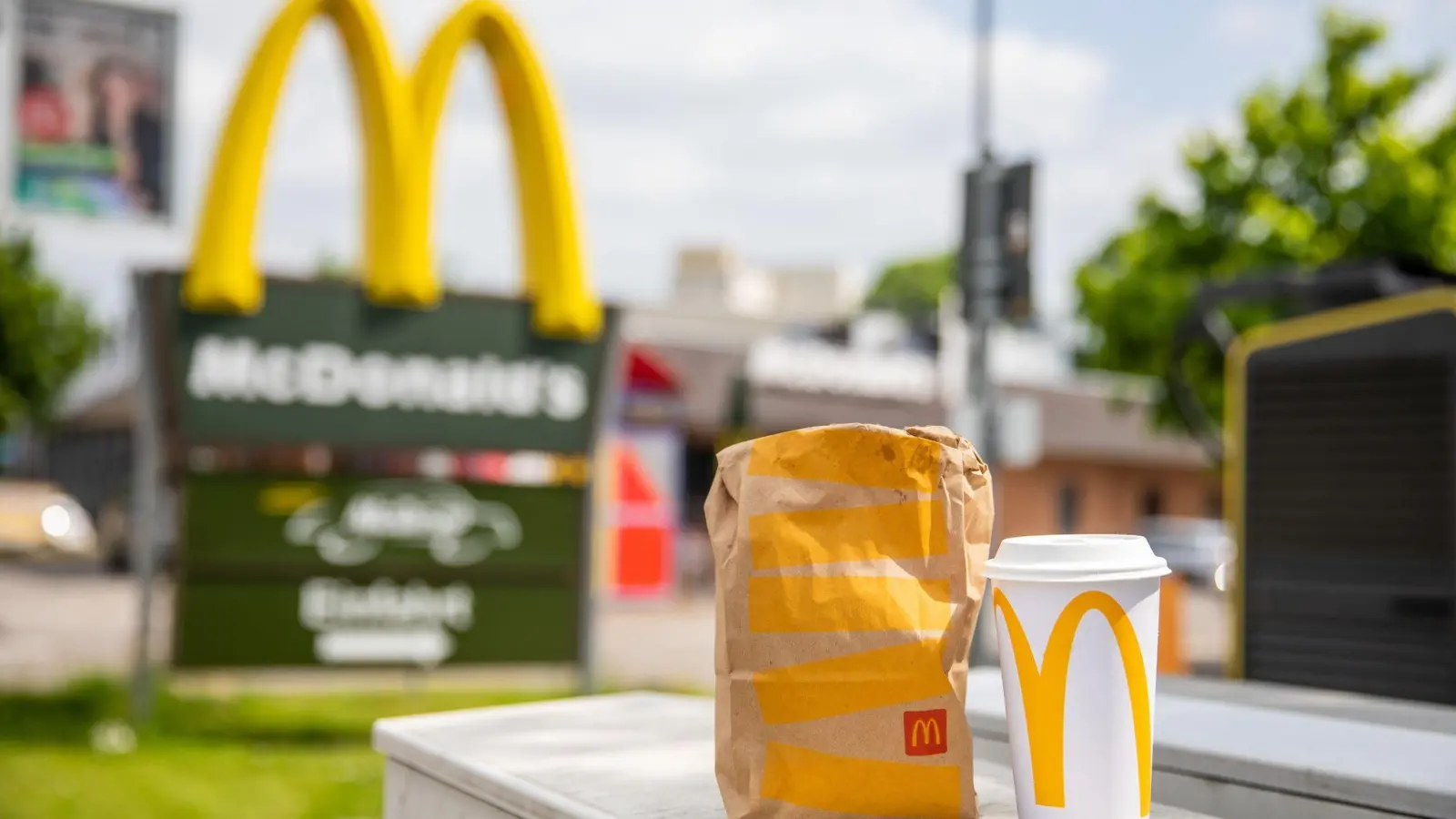 Eine McDonald&#39;s To-go-Tüte und ein dazugehöriger To-go-Becher stehen vor einer Tübinger McDonald&#39;s Filiale. (Foto: Christoph Schmidt/dpa)