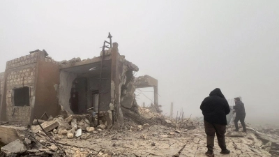 Syrer blicken auf eine verlassene medizinische Einrichtung, die nach Angaben der freiwilligen Rettungsorganisation White Helmets am späten Montagabend von iranischen Raketen getroffen wurde. (Foto: Omar Albam/AP/dpa)