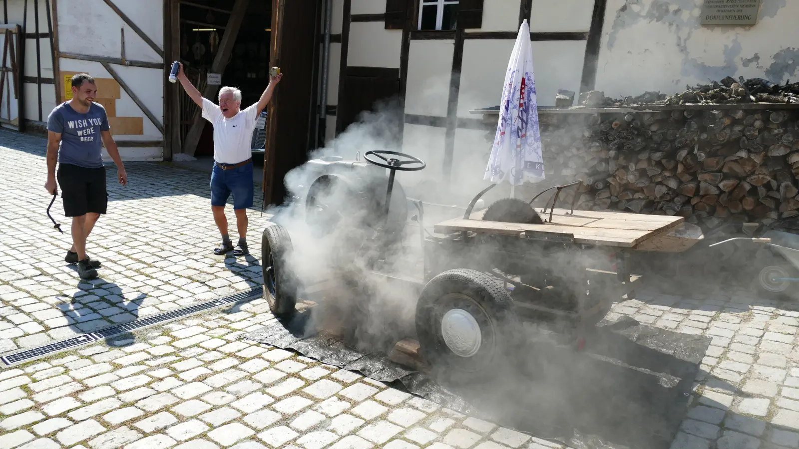 Die aus dem Jahr 1939 stammende mobile Kreissäge meldete sich mit einer Rauchwolke zurück. Emil Stieber (rechts) und Florian Beigel (mit Handkurbel) vom Frohsinnshof in Oberntief jubeln. (Foto: Sylvia Fehlinger)