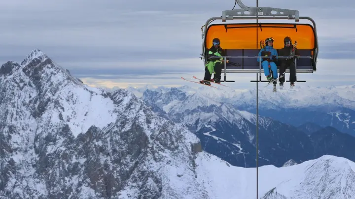 Wintersportler sitzen auf der Zugspitze in einem Sessellift. (Foto: Karl-Josef Hildenbrand/dpa/Symbolbild)