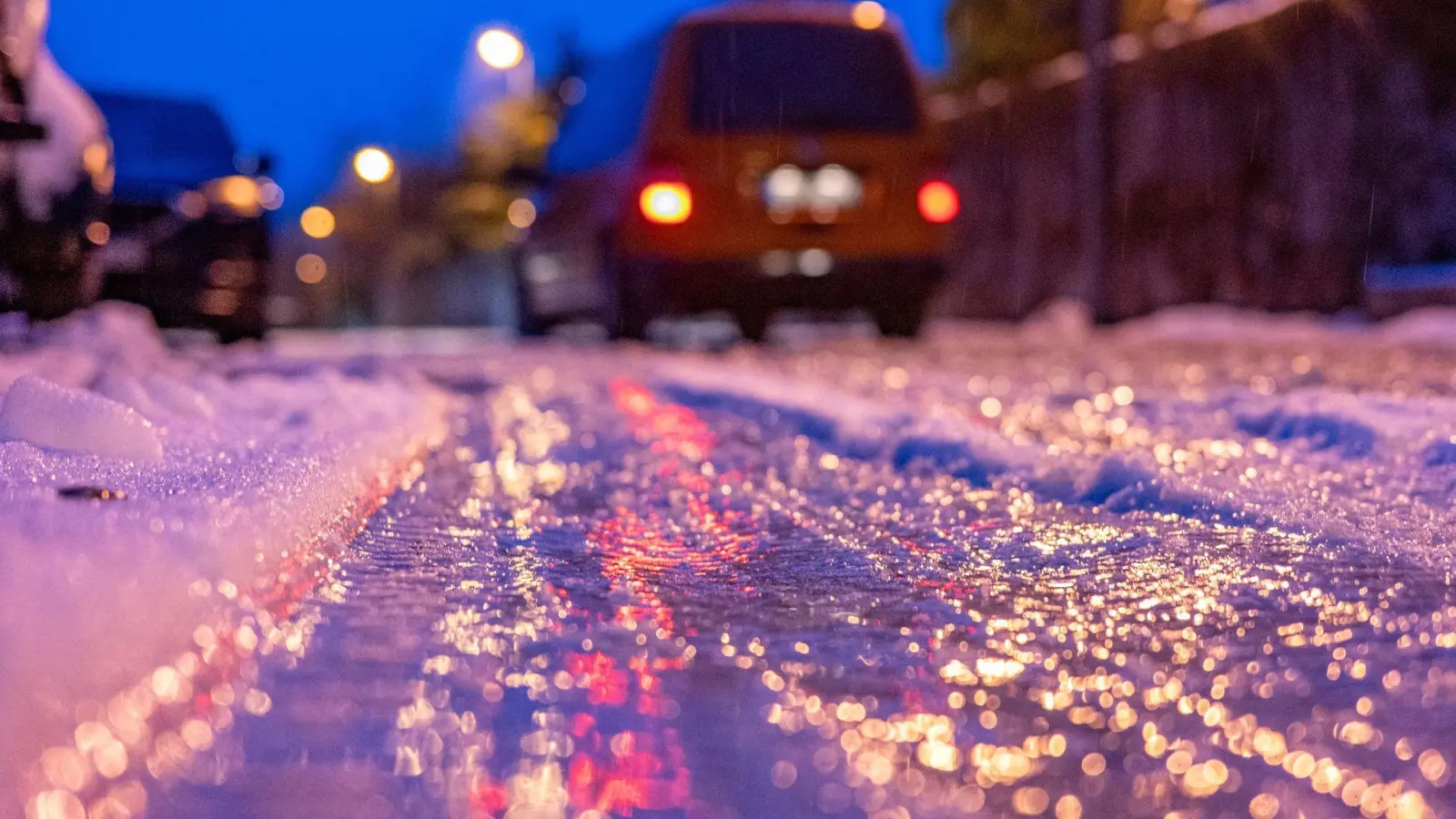 Eine dünne Eisschicht überzieht am frühen Morgen eine Straße. (Foto: Armin Weigel/dpa/Symbolbild)