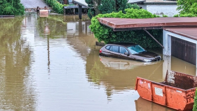 Ein Auto steht auf einer überfluteten Straße. Es ist zu erwarten, dass die Pegelstände weiter steigen werden. (Foto: Jason Tschepljakow/dpa)