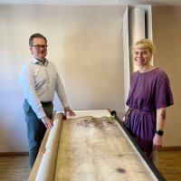 Christian Mantsch und die Restauratorin Nina Steininger mit einer bereits gereinigten Karte, auf der eine kolorierte Handzeichnung aus dem Jahr 1728 zu sehen ist. (Foto: Alexander Schmidtke)