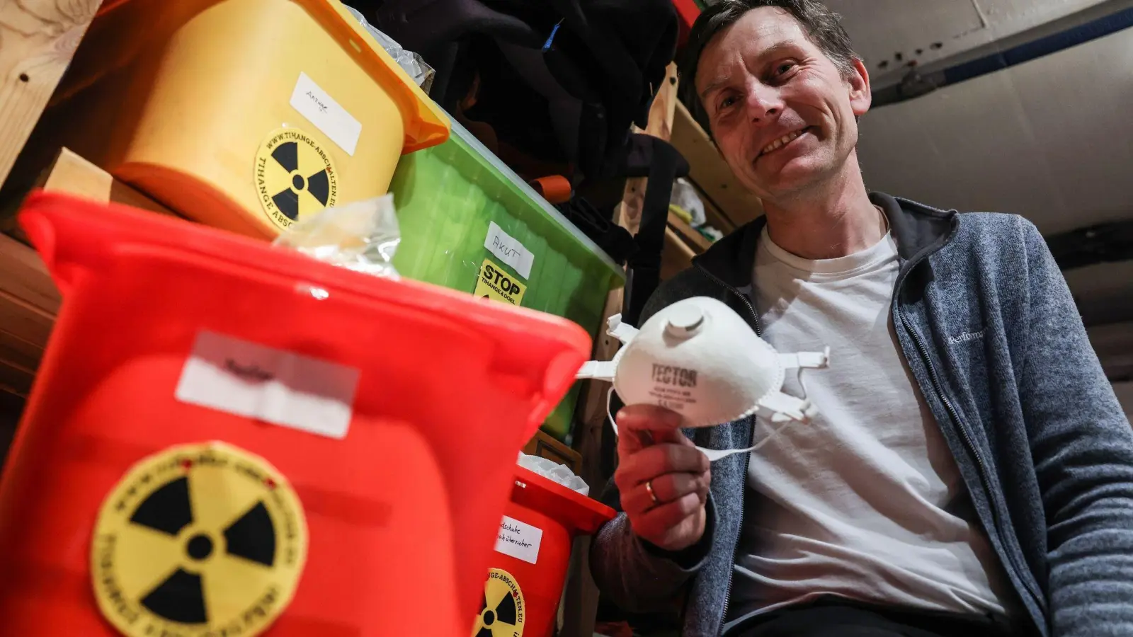 Der Anti-Atomkraft-Aktivist Gereon Hermens sitzt in seinem Keller neben Kisten mit Schutzausrüstungen. (Foto: Oliver Berg/dpa)