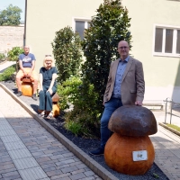 Kunst mit gewissen Vorzügen: Auch zum Anlehnen oder als gemütlicher Sitzplatz eignen sich die drei Pilze am Uffenheimer Rathaus – finden auch Thomas Schmitt, Helga Kerwagen und Thomas Siebert (von rechts).  (Foto: Johannes Zimmermann)