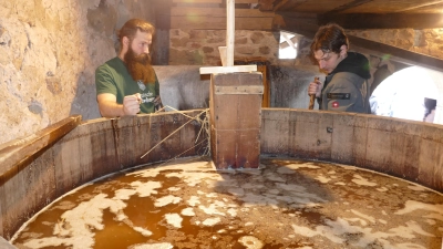 Pascal Schüdekopf (links) und Bastian Merches beim Umschöpfen der 1500 Liter Bier von einem Bottich in den anderen. (Foto: Sylvia Fehlinger)