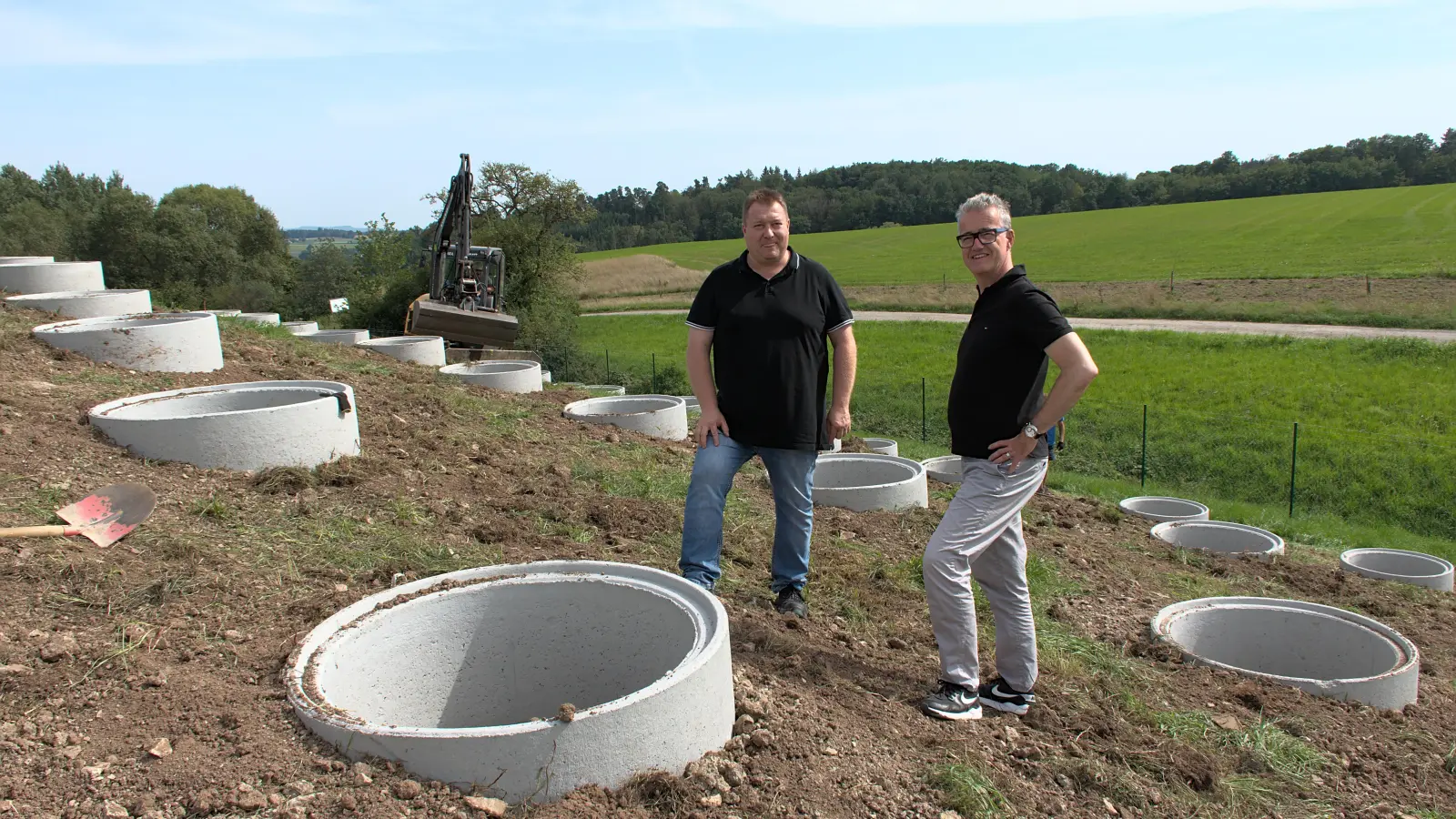 Auf der früheren Deponie werden derzeit rund 700 Schachtringe gesetzt. In sie betonieren die Arbeiter dann die Unterkonstruktionen für die Solarmodule ein. Über den zügigen Fortschritt beim Bau der nunmehr zweiten Photovoltaik-Freiflächenanlage der Stadtwerke-Tochter nahKRAFT GmbH informierten sich Bürgermeister Patrick Ruh (rechts) und Werke-Mitarbeiter Alexander Strauß jetzt vor Ort. (Foto: Stadt Feuchtwangen / Rebecca Weber)