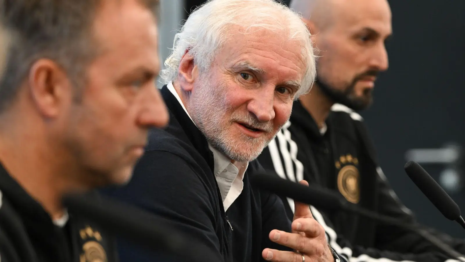 DFB-Sportdirektor Rudi Völler (M.) setzte sich bewusst zwischen Bundestrainer Hansi Flick (l) und U21-Coach Antonio Di Salvo. (Foto: Arne Dedert/dpa)