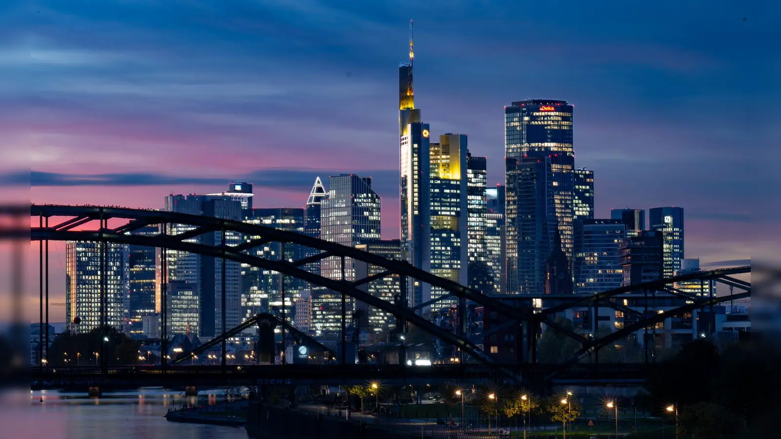 Die Lichter der Bankenskyline von Frankfurt leuchten in der Abendstimmung. (Foto: Boris Roessler/dpa)
