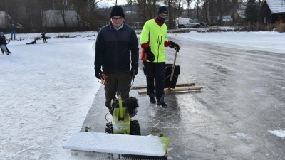 Luca Bauer (links) und Jonas Grünbaum befreien den Eisweiher mit ihren teils selbst konstruierten Geräten vom störenden Schnee. (Foto: Ute Niephaus)
