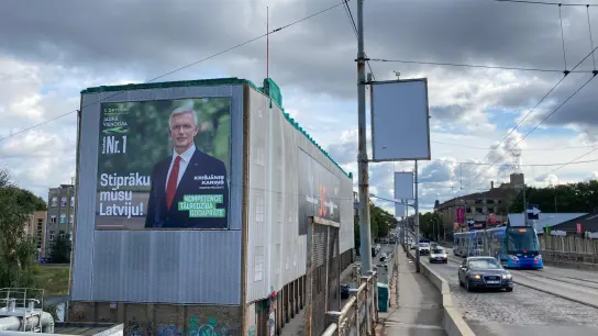 Ein Wahlplakat der liberalkonservativen Regierungspartei mit einem Porträt von Ministerpräsident Krisjanis Karins hängt an einer Hauswand in der Hauptstadt Riga. (Foto: Alexander Welscher/dpa)