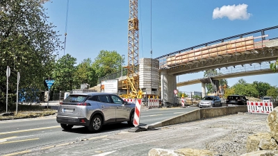 Noch ist im Brückenbereich die Durchfahrt mit zehn Stundenkilometern möglich. Ab Montag, 17. August, kommt es dort dann aber zu einer zweiwöchigen Vollsperrung, weil das alte Bauwerk (hinten) abgerissen wird. Im Vordergrund ist die neue Brücke zu sehen. (Foto: Jürgen Binder)
