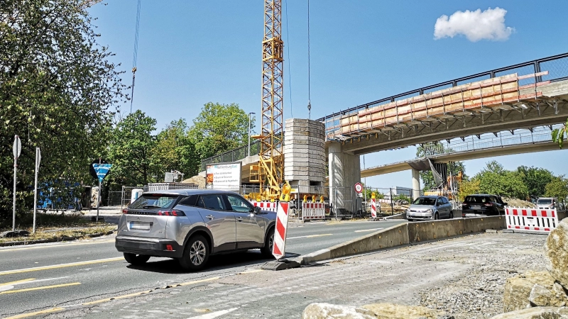 Noch ist im Brückenbereich die Durchfahrt mit zehn Stundenkilometern möglich. Ab Montag, 17. August, kommt es dort dann aber zu einer zweiwöchigen Vollsperrung, weil das alte Bauwerk (hinten) abgerissen wird. Im Vordergrund ist die neue Brücke zu sehen. (Foto: Jürgen Binder)