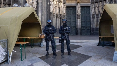 Polizisten mit Maschinenpistolen stehen vor dem Kölner Dom. Nach dem Terroralarm für das Gotteshaus sind drei weitere Verdächtige festgesetzt worden. (Foto: Thomas Banneyer/dpa)
