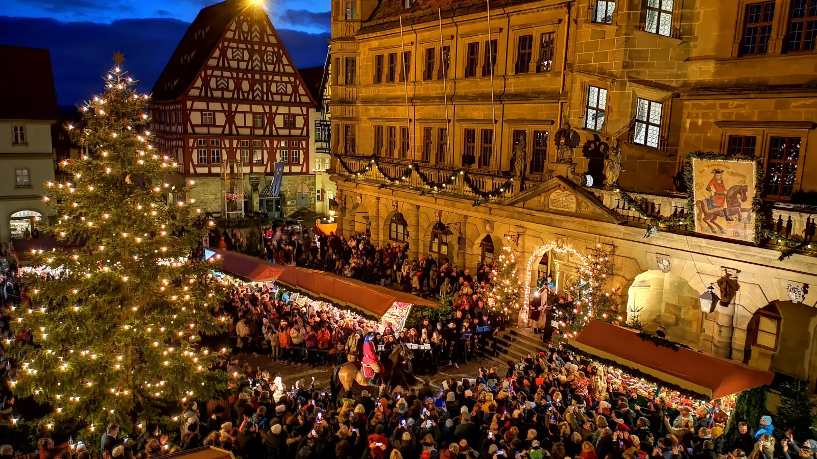 Durch eine große Menschenmenge und am kurz zuvor erstmals angeschalteten Christbaum vorbei bewegte sich Pferd Da Vinci mit Timo Herrscher im Sattel gestern Abend sicheren Schrittes auf das Rathausportal zu. Das neue Reiterle legte eine souveräne Premiere hin. (Foto: Jürgen Binder)